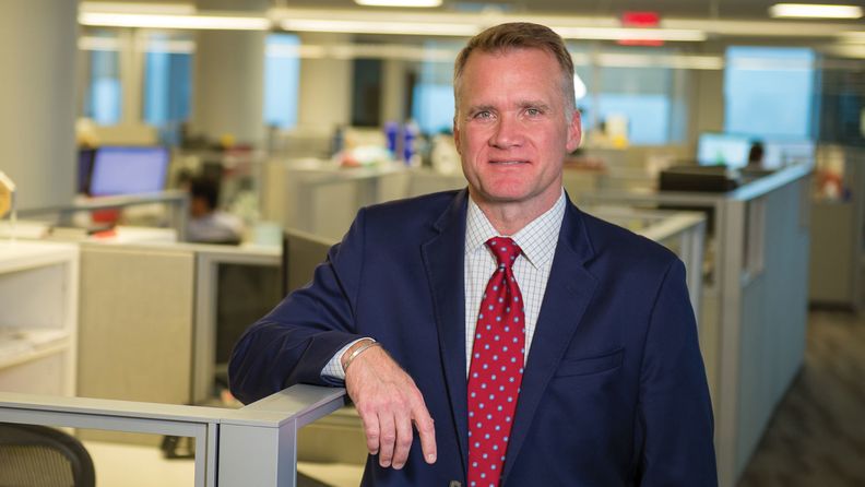 Steven F. Charlton of NEPC leaning on cubicle, photo by Stanley Rowin