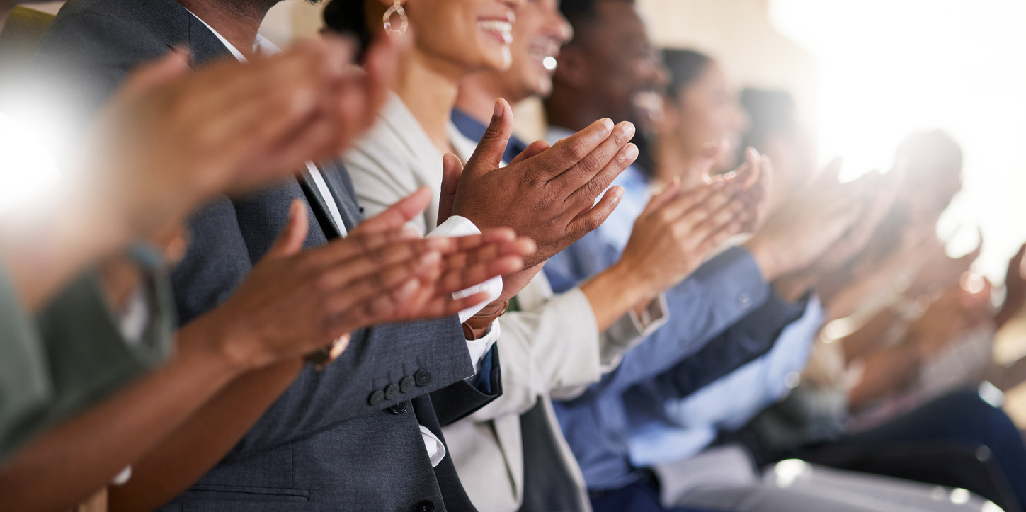 Cropped shot of an unrecognizable diverse group of businesspeople applauding while sitting in the boardroom during a presentation