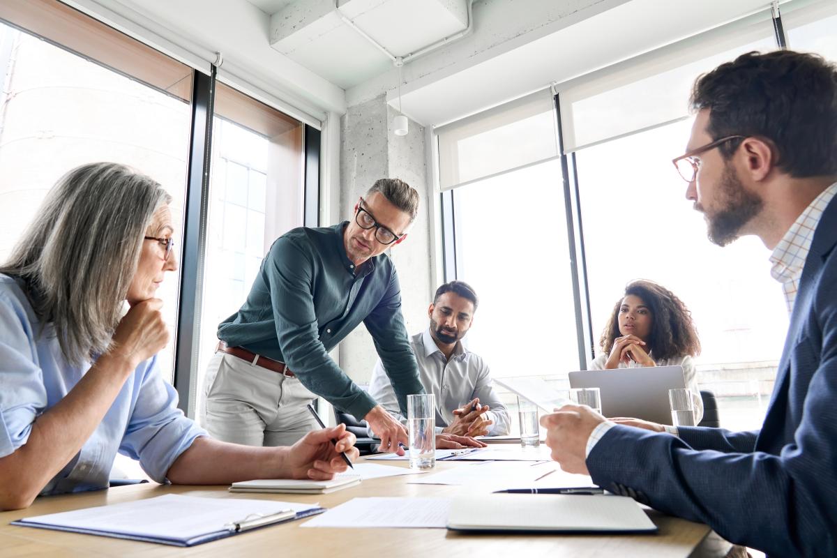 Advisors meeting, both male and female, in office setting around conference table