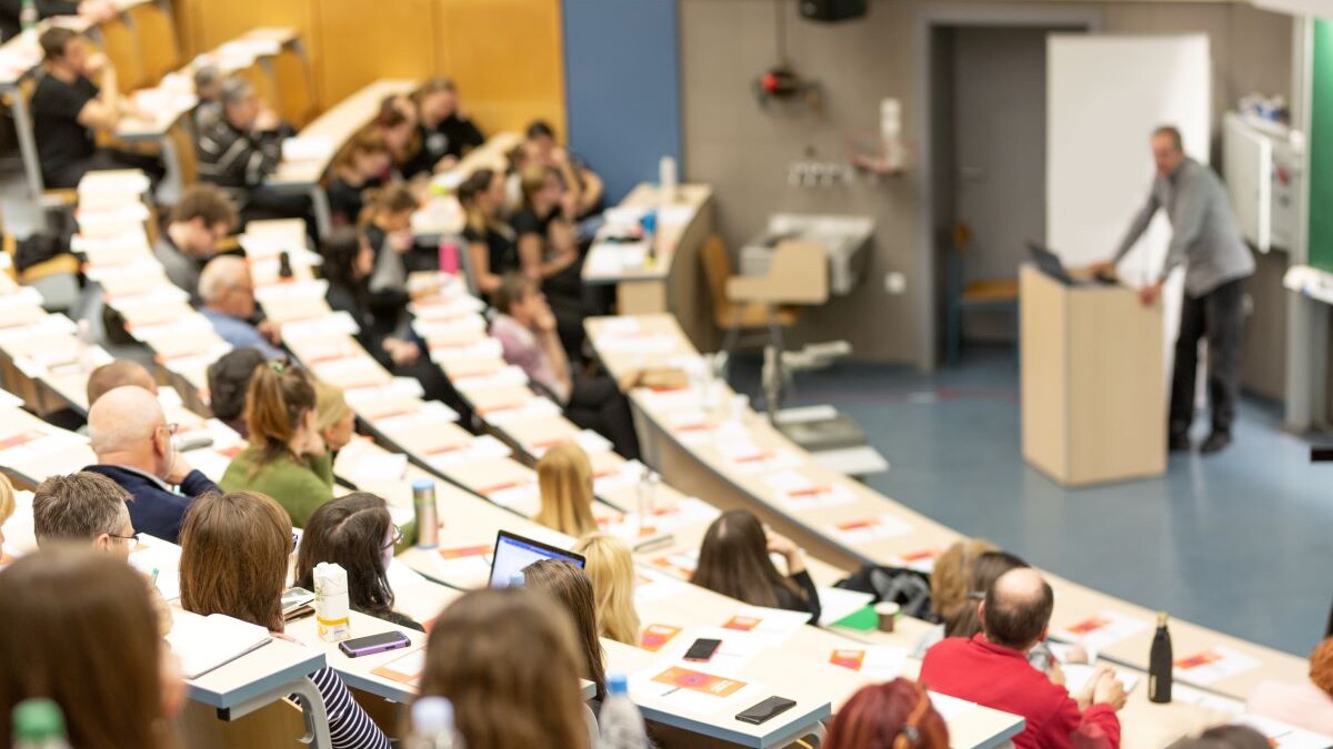 Audience seated in a university lecture hall.