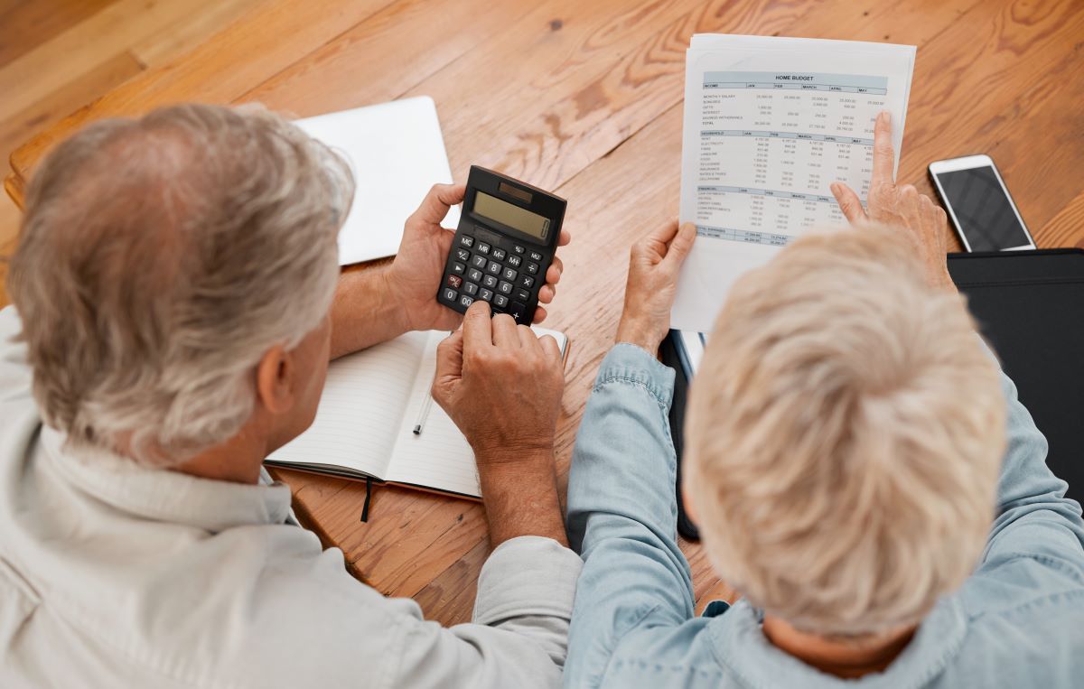 senior couple with calculator planning financial investments